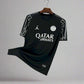 Black sports jersey with Qatar Airways logo on a hanger against a wire mesh background