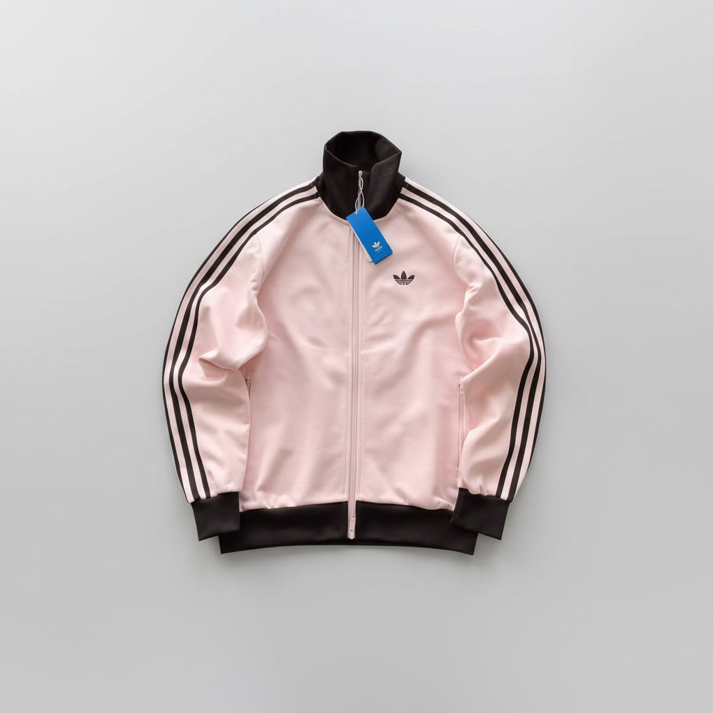 Pink Adidas jacket with black stripes on a wooden floor