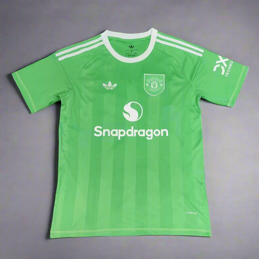 Green sports jersey with Adidas and other brand logos on a grass background