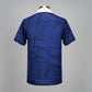 Blue patterned polo shirt on a hanger against a wire mesh background