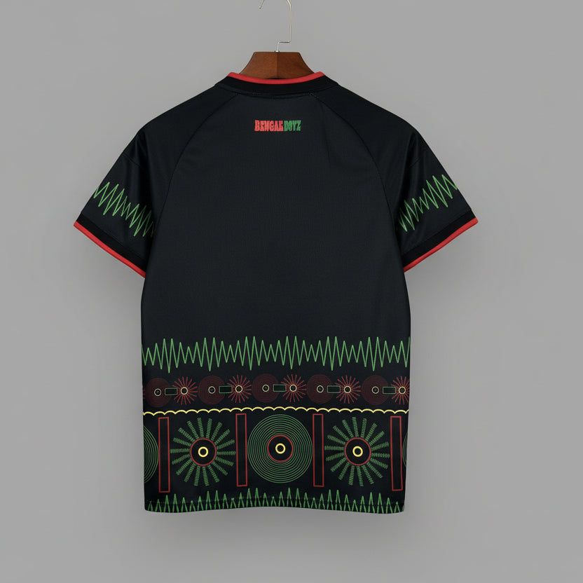 Black shirt with green and red patterns on a hanger against a grid background