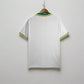 White sports jersey with green and yellow accents hanging on a rack.