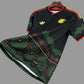 Black sports jersey with green and red patterns on a hanger against a grid background
