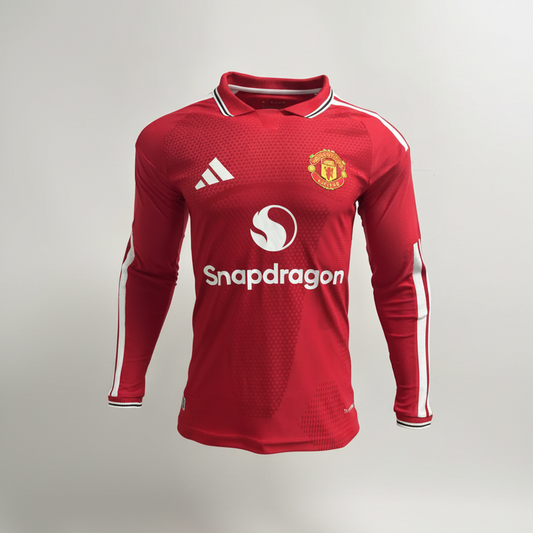 A red long-sleeve Manchester United soccer jersey displayed on a black mannequin torso. The jersey features a subtle textured pattern, white Adidas logo on the right chest, Manchester United crest on the left chest, and a white Snapdragon sponsor logo across the center.