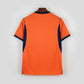 Orange shirt with navy accents on a black metal rack.