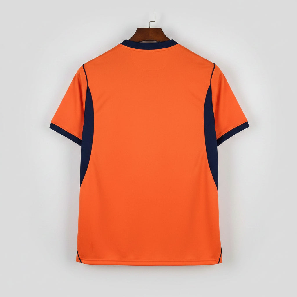 Orange shirt with navy accents on a black metal rack.
