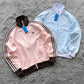 Pink and light blue Adidas jackets on a white background