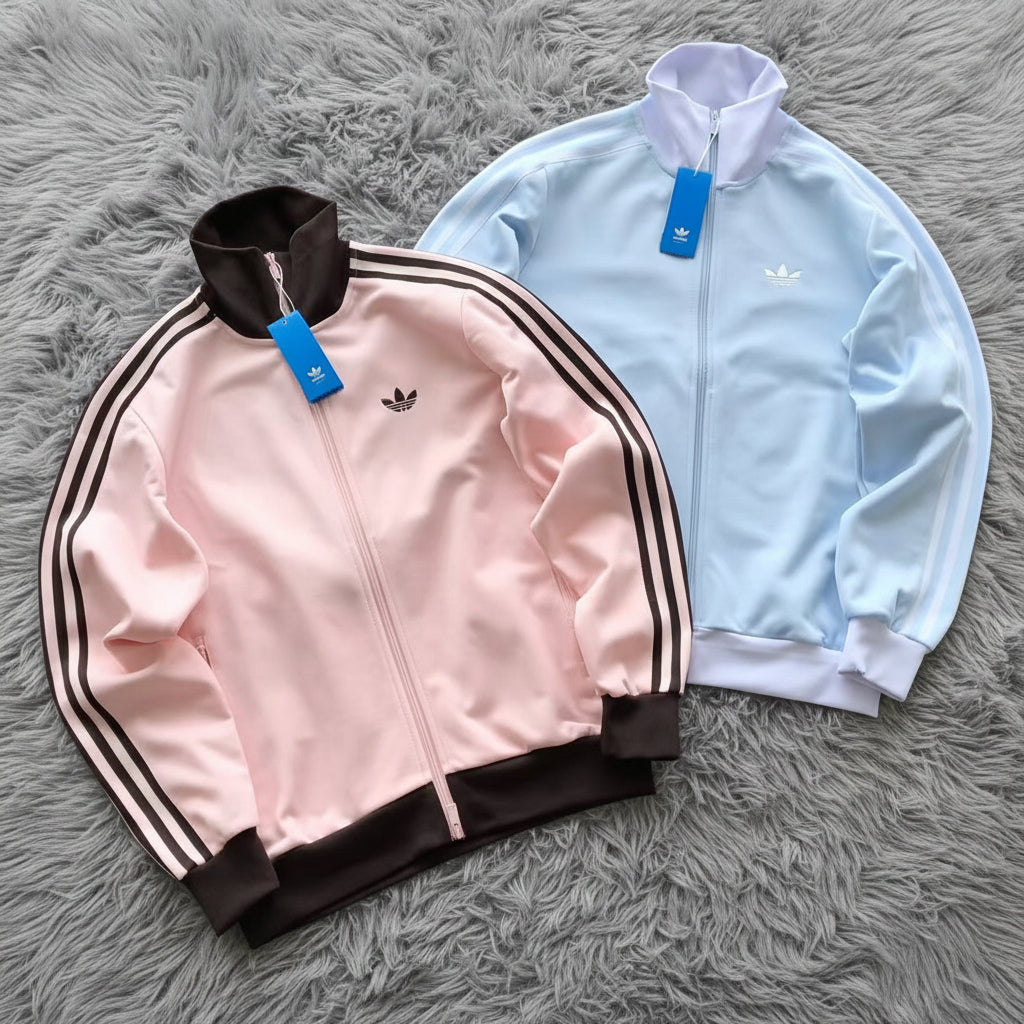 Pink and light blue Adidas jackets on a white background