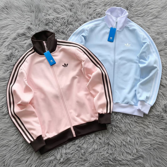 Pink and light blue Adidas jackets on a white background
